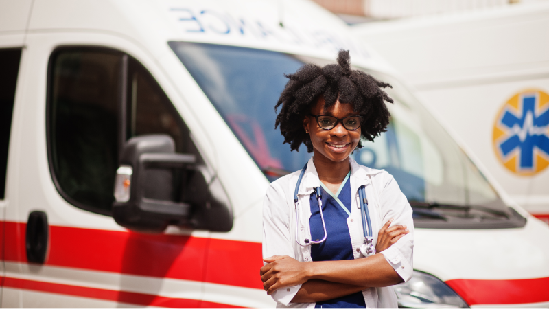 Black Female EMT Standing in front of an ambulance